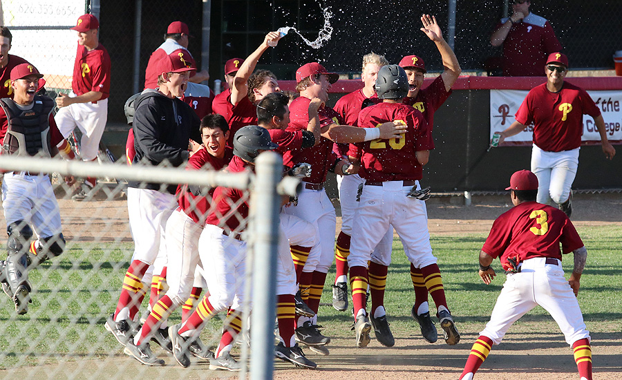 The first-place PCC baseball team celebrates a walk-off win as they swarm John Bicos, who scored the final run on a wild pitch Tuesday, photo by Richard Quinton.