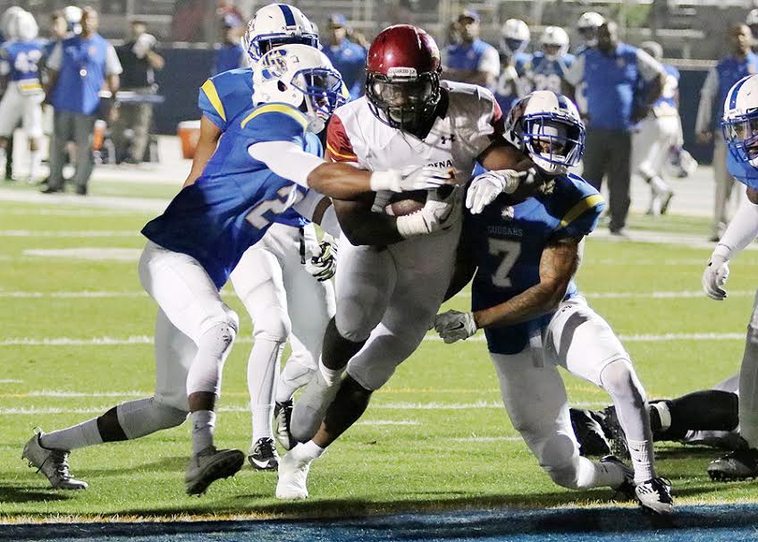 Kevin Thomas squeezes through LA Southwest tacklers for a touchdown during PCC's fifth straight win Saturday night, photo by Richard Quinton.