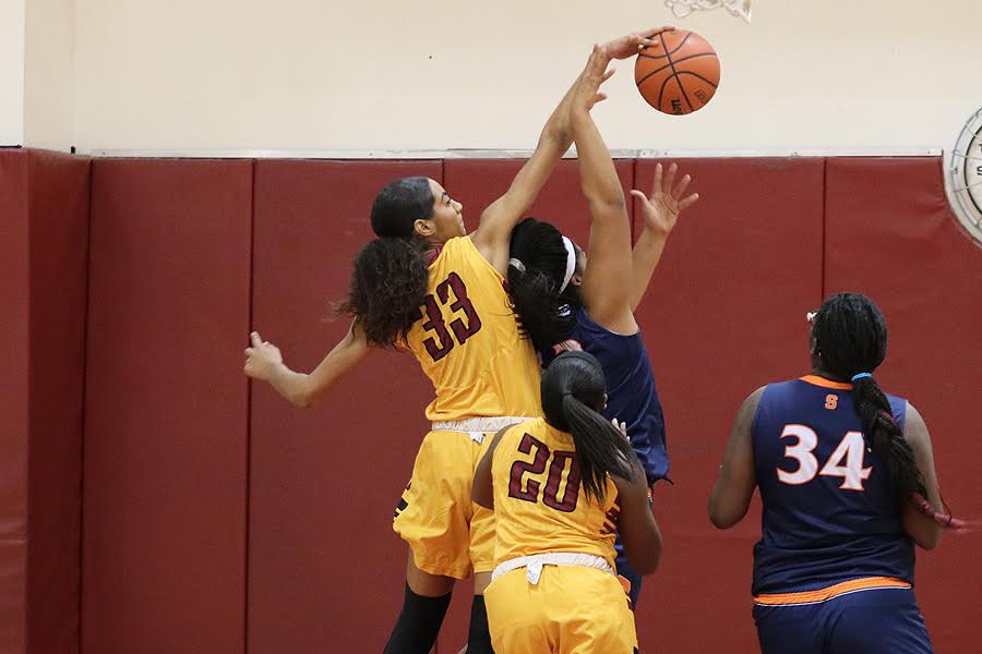 Kailyn Gideon, sophomore center, blocks a shot in a recent game, image by Richard Quinton.