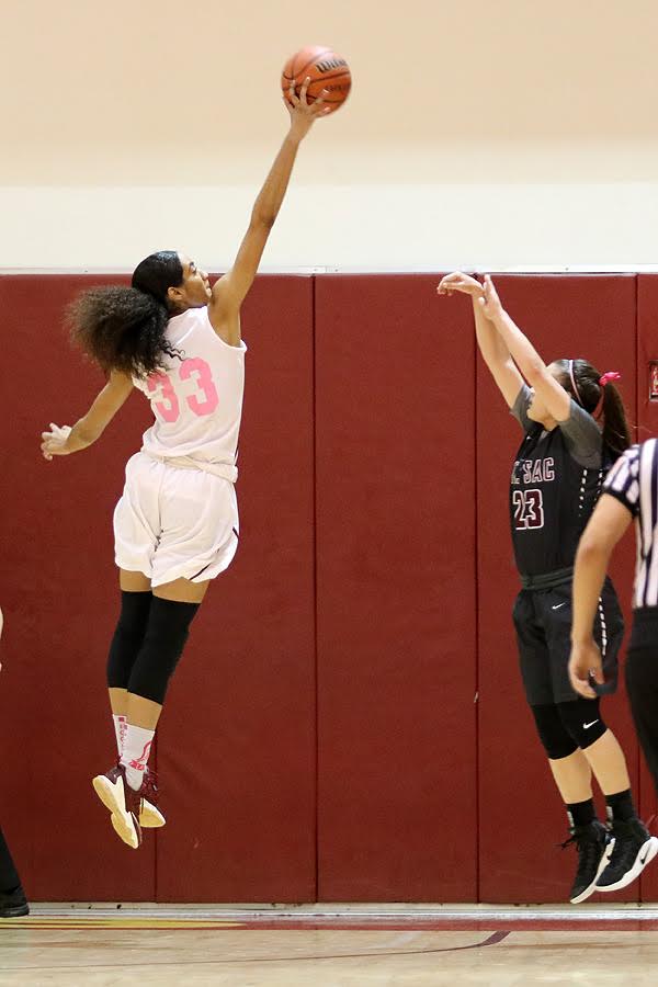 Kailyn Gideon goes up high to block the 3-point shot attempt of Mt. SAC's Maddeline Dopplick Wednesday night. The Lancers wore their special Coaches v. Cancer pink/white uniforms in the defeat, photo by Richard Quinton.