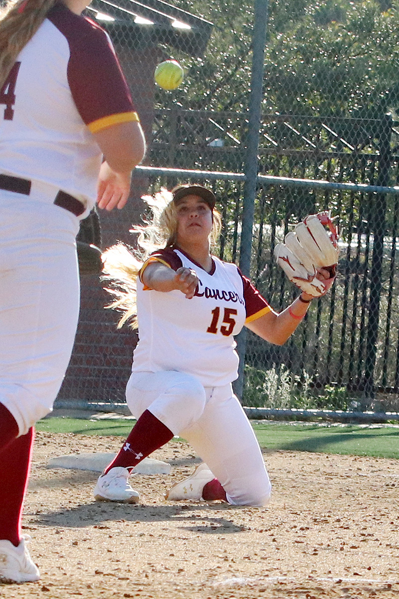 PCC third baseman Lexy Rios makes the sparkling defensive play as she makes a successful throw to first from her knee during Tuesday's win, photo by Richard Quinton.