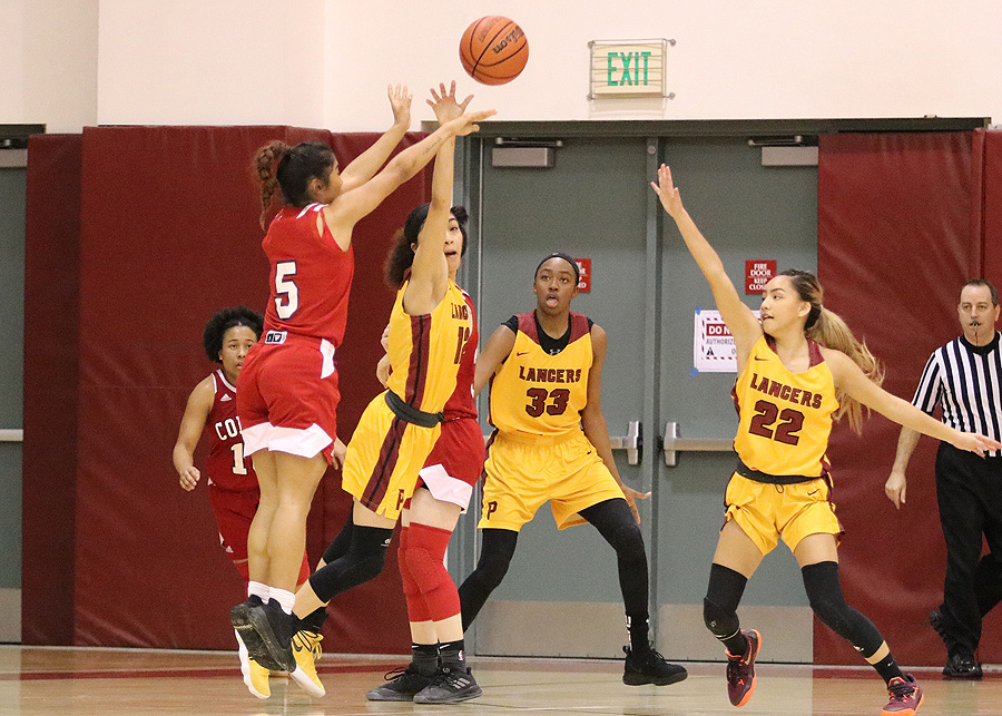 Lancer Daniela Mendez gets her hand on Palomar's Julie Saelee's 3-point attempt for the block that helped PCC win its Round 2 Regional Playoff Friday night, photo by Richard Quinton.