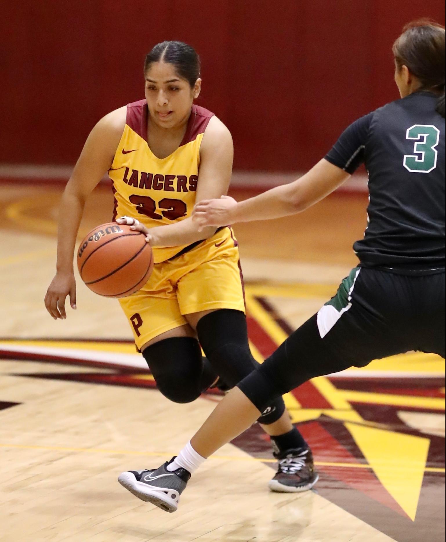 Lupe Vazquez dribbles it up court v. East LA in PCC's loss Friday night (photo by Michael Watkins, Athletics).