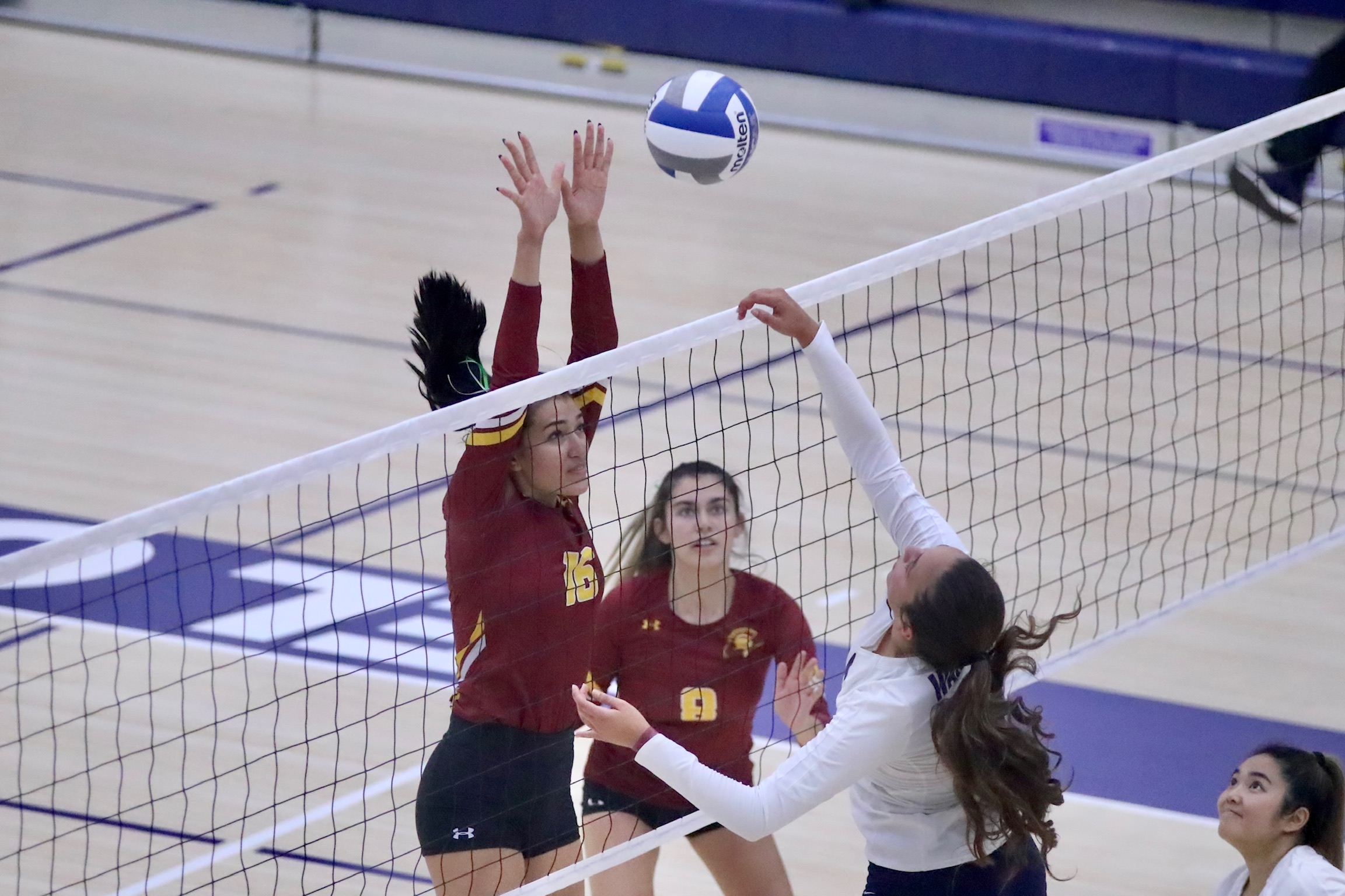 Paulina Lopez stretches out with both her hands and hair high as she attempts a block with teammate Nalani Young looking on in PCC's win at El Camino College Friday evening (photo by Michael Watkins).