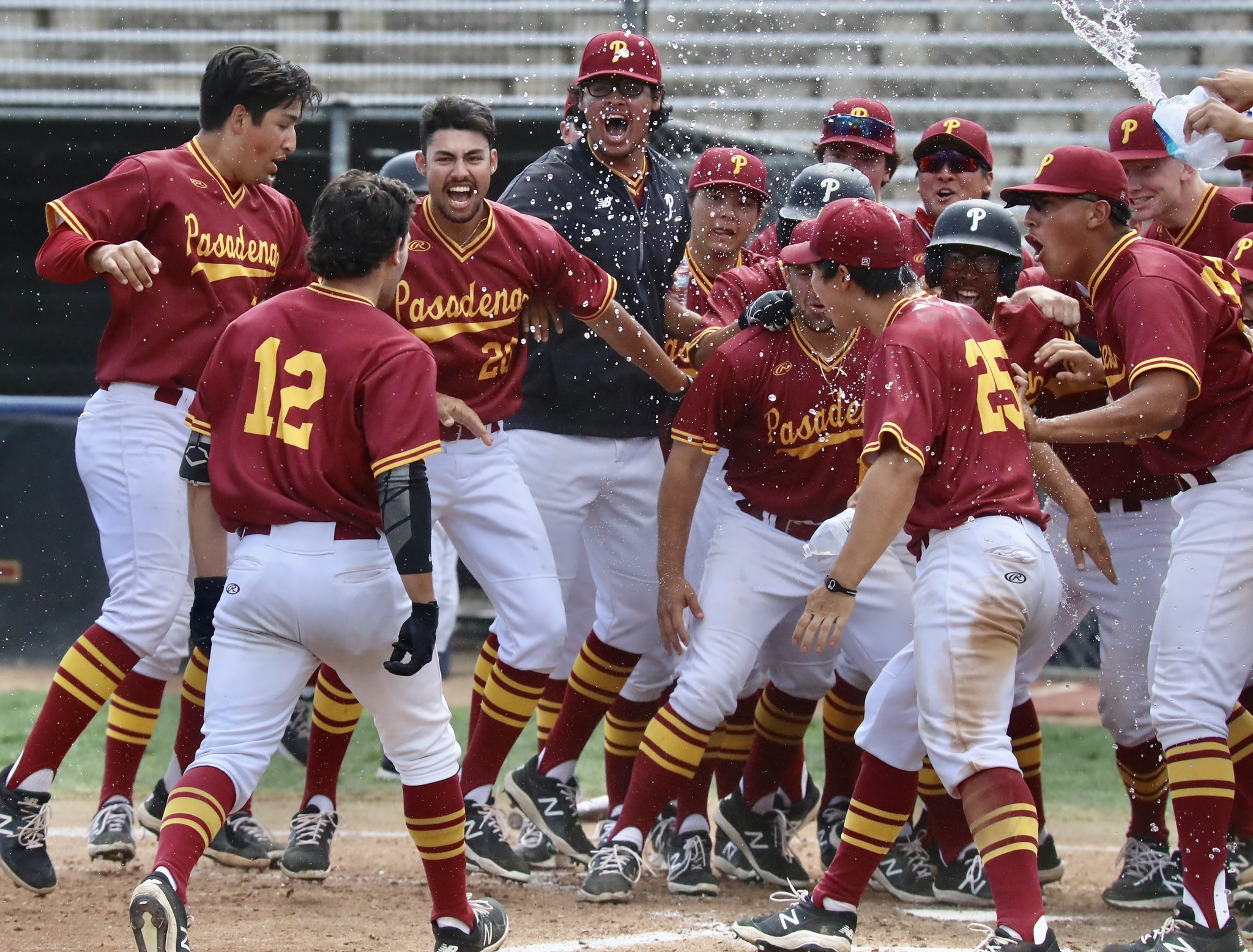 Matt Rice (#12) is greeted at home plate by his teammates following his walk-off HR on Saturday (photo by Michael Watkins, Athletics)