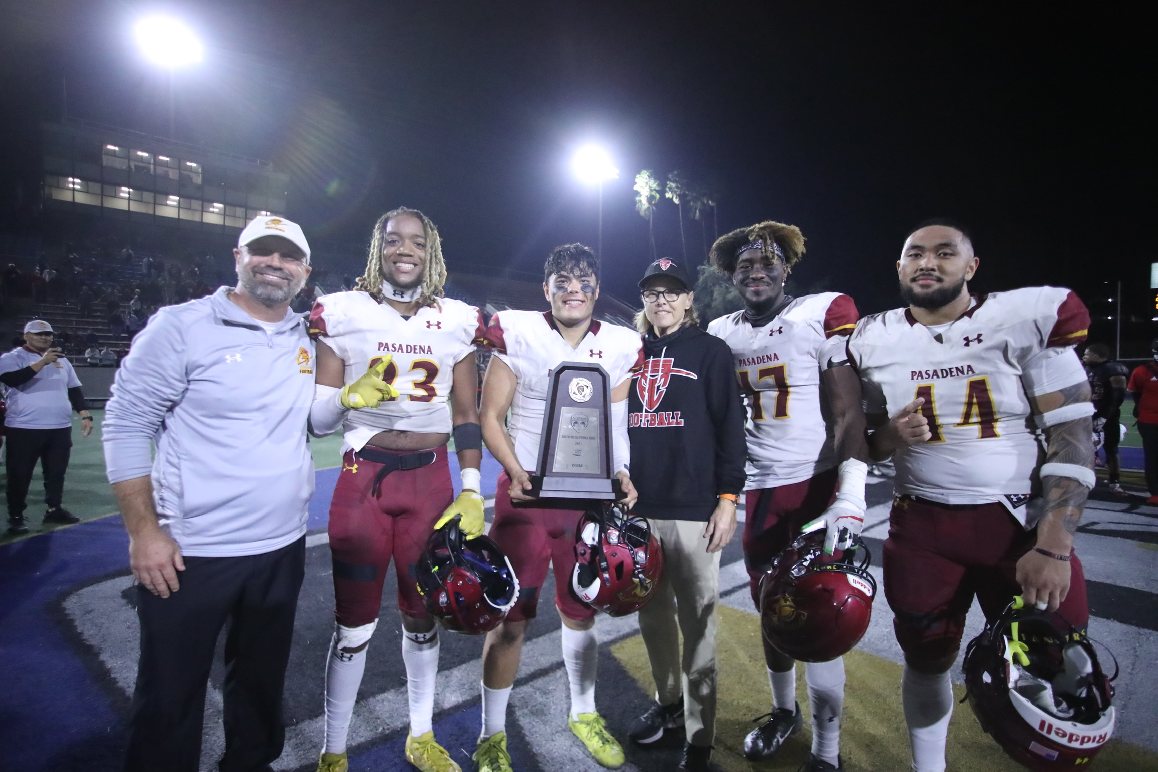 Coach Robert Tucker celebrates with his team captains winning the SoCal Bowl championship on Saturday night. Kaydon Spens, Kade Wentz (with trophy), Justen Campbell, and Michaelangelo Loretto (photo by Michael Watkins).